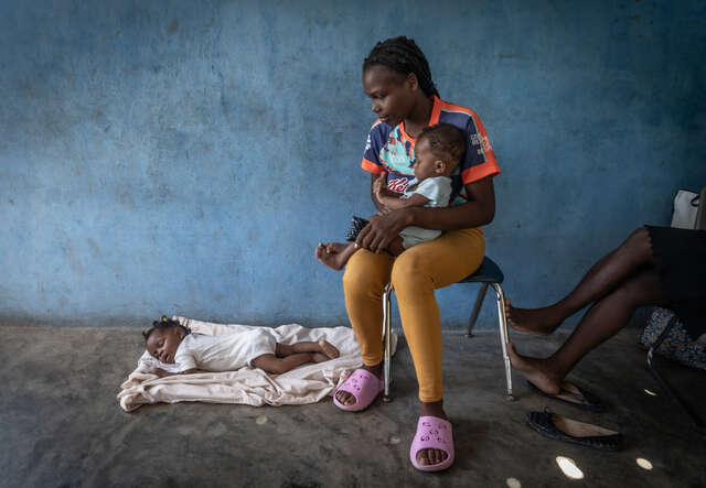 A mother and her two children seek refuge in a temporary shelter in Haiti.