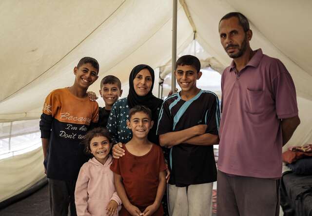 Family under their tent looking at the camera