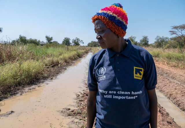 An IRC client walks through a flooded field in South Sudan.