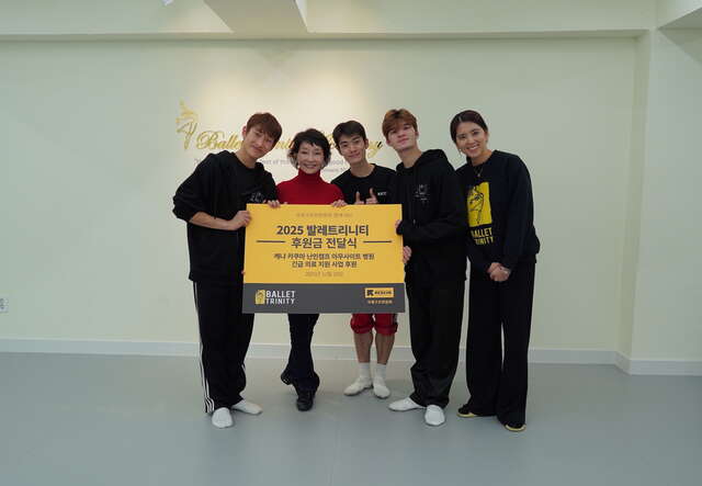 다섯 명의 무용수들이 기부판넬을 들고 웃으며 포즈를 취하고 있습니다.