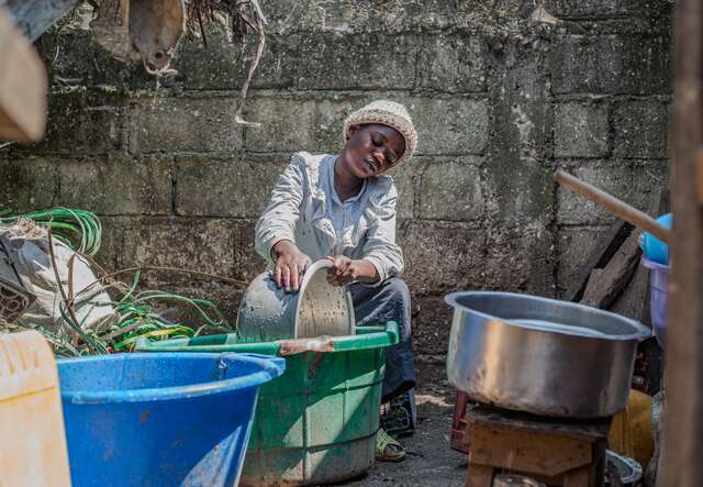 Gentille washing dishes in her new home.