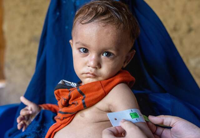 A young child is screened for malnutrition by an IRC staff member in Afghanistan..