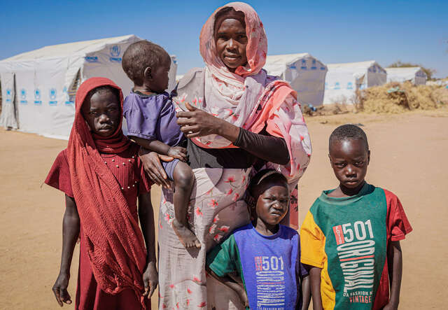 Bousseina poses for the photo, surrounded by her children.