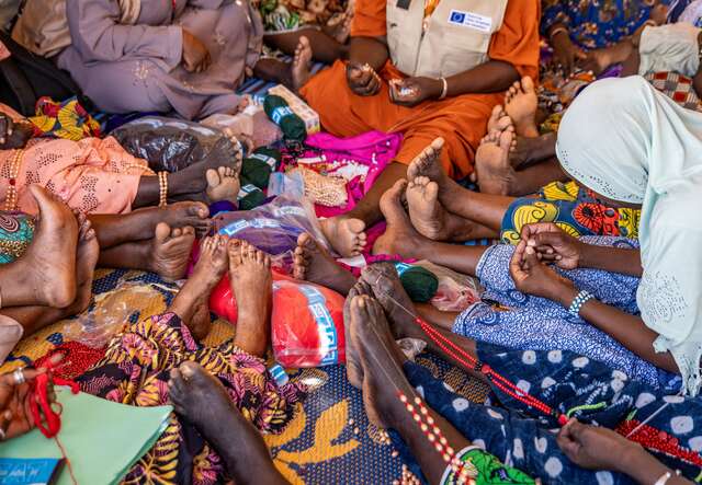 A group of women in a circle taking part in a psychosocial support session. 