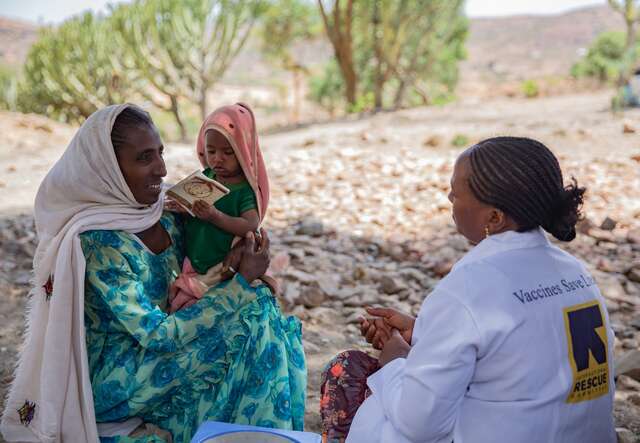 An IRC staff member consults a mother and her child.