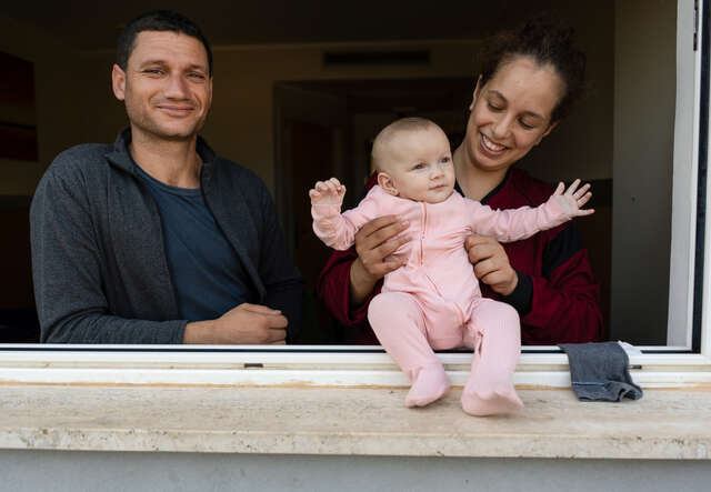 Imed, Amira och Aya kollar ut genom ett fönster. 