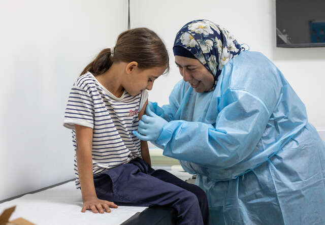 Eine Krankenschwester impft ein junges Mädchen in Libanon.