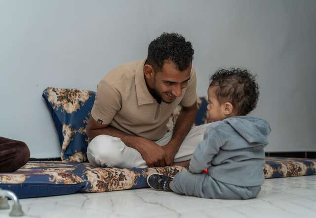 Nader smiling at his son. 