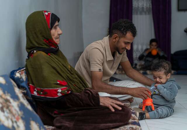 Nader consoles his son, Aws, while spending quality family time at home with his grandmother.