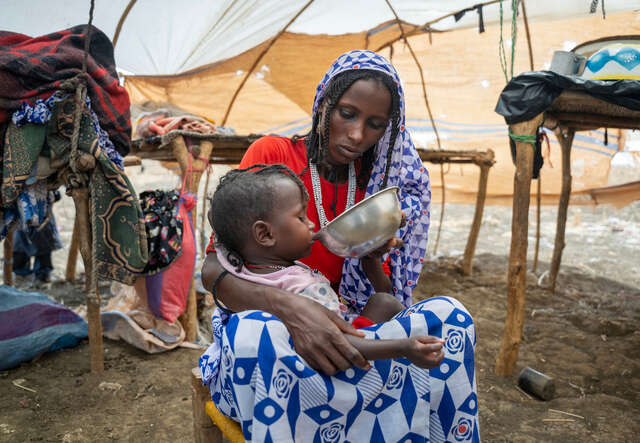 En mamma som matar sitt barn i Sudan. 