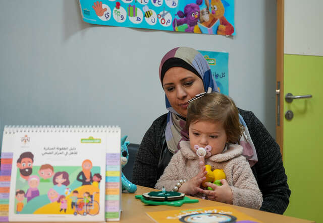 Layali holds her young daughter, Ayla, in her lap.