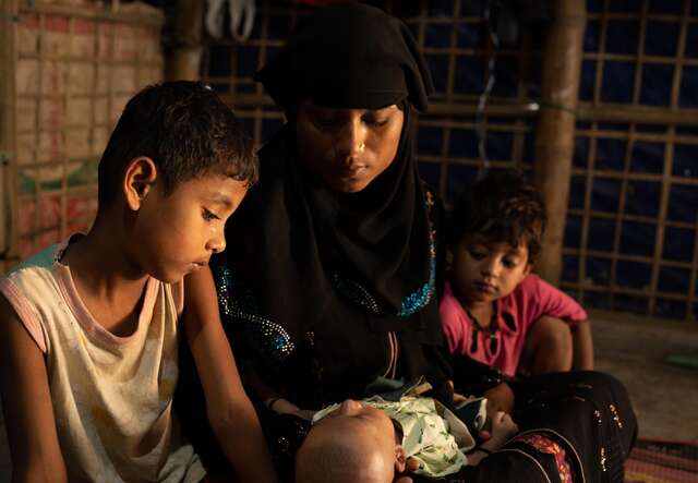 Samira with her three children as they wait in their living room for guests to arrive. Samira finds joy in spending time with her children.