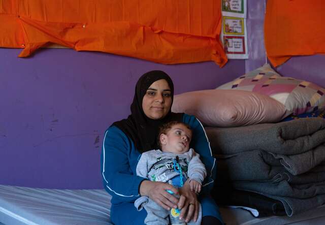 Warda holds her baby, Mohammad, in her lap.