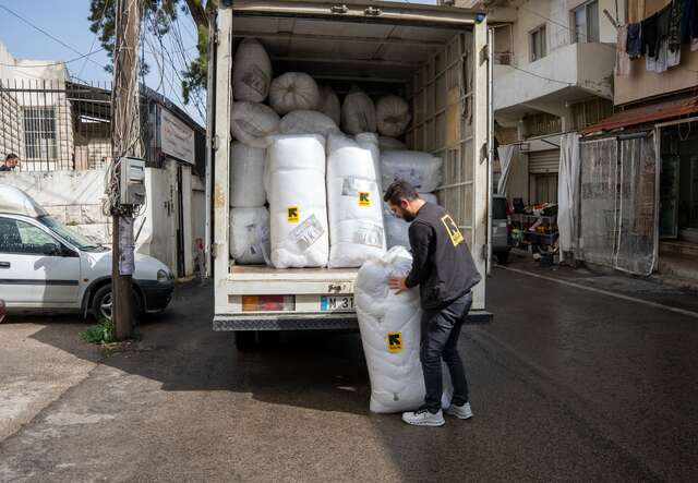 An IRC staff member unloads humanitarian aid supplies in Lebanon.