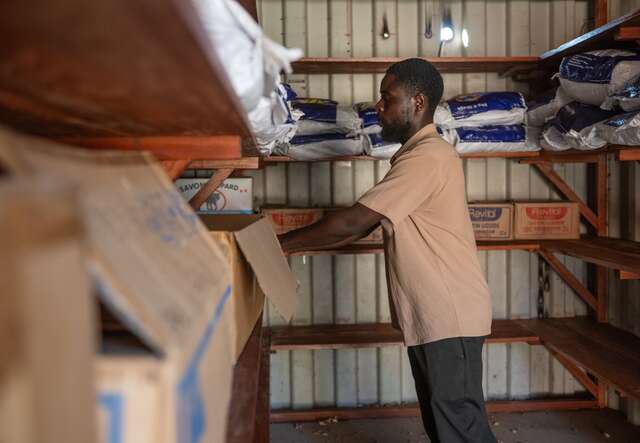 An IRC day laborer stocks IPC kits for the Ebola/Bundibugyo virus response in Centenaire, Bunia, DRC. 