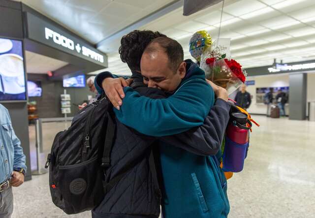 Two people embrace after a family reunification at an airport in the US.
