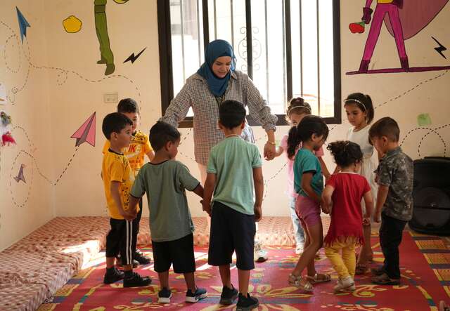 An IRC staff member leads a psychosocial session with children in Lebanon.