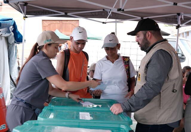 People approach the mobile health unit run by the IRC’s partner PALUZ to access primary health care, where Everardo assists.