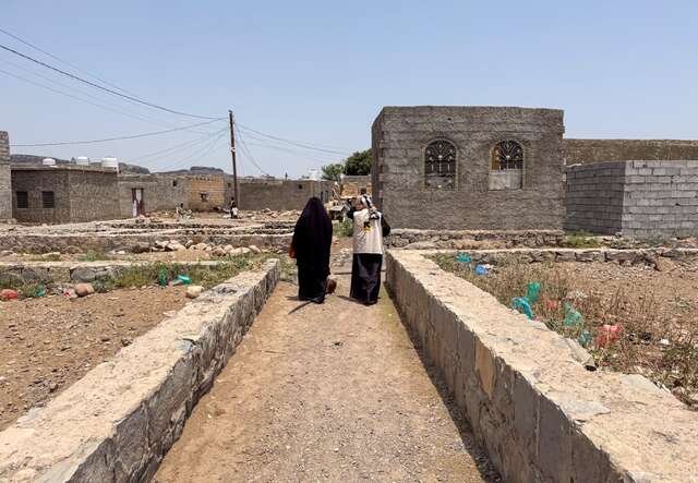 Basma walks with an IRC staff member 