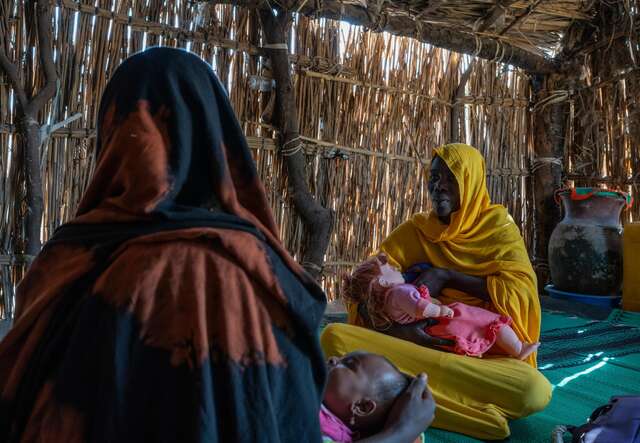 Bintou showing her fellow community member, Kakai Ndjouka, the optimal breastfeeding method for her 1-year-old baby.