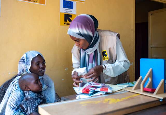 An IRC health worker speaks with Shama and her son, Anwar.
