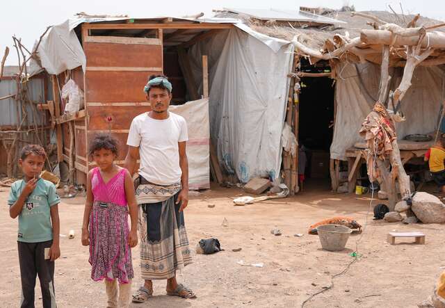 Ahmed, his son, and daughter outside their home.