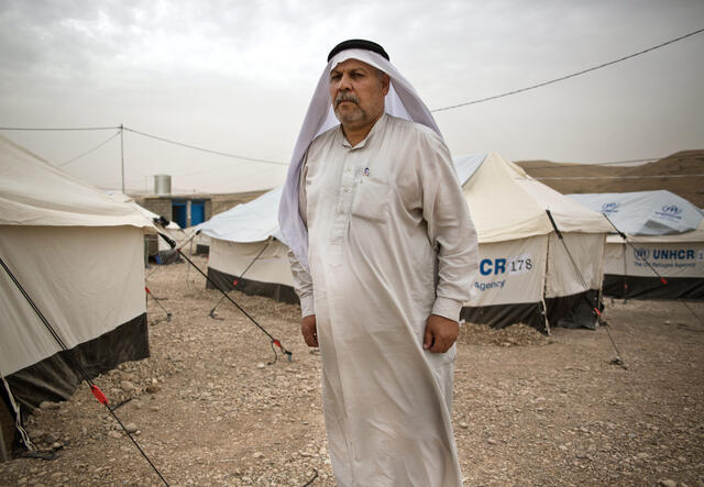 An Iraqi man who works as a shepherd stands among tents in a camp for families displaced by the battle for Mosul