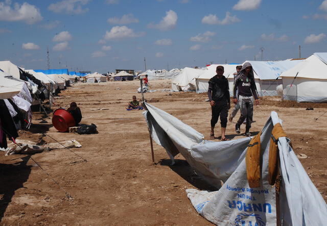 Iraqi refugees walk along a row of tents in Al Hol camp in northeast Syria.