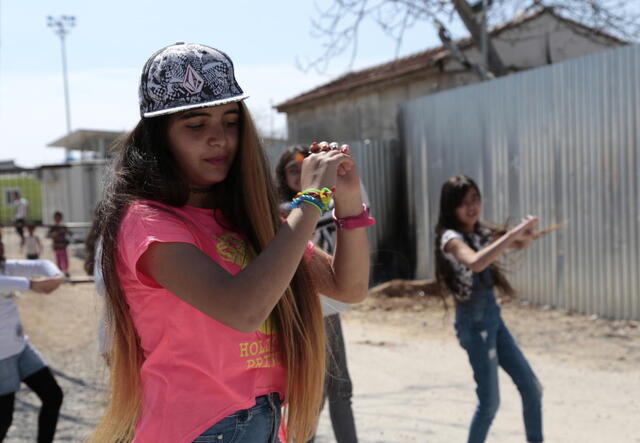 Rolian, 16, shows off her dance moves at Eleonas refugee camp in Greece.