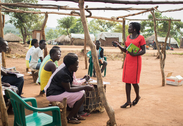 Lilian Dawa stands before a church congregation in Bidi Bidi during an outdoor service.