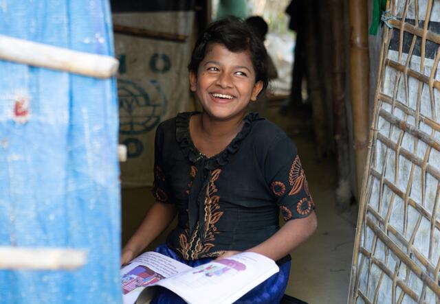 Rubijan sitting down with an open book in her hands