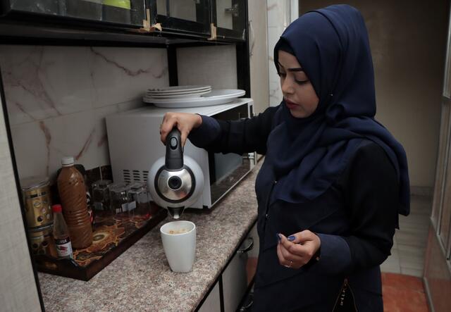 Bushra pouring hot water into a cup