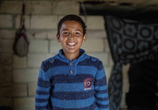 10-year-old Tareq smiles at the camera.