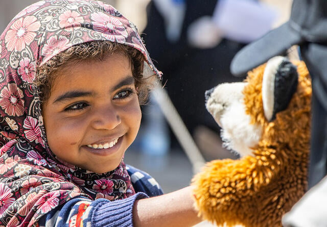 Young girl smiles at a fox puppet