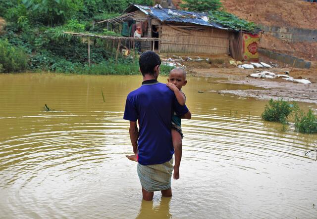 Man crossing a river holding a child