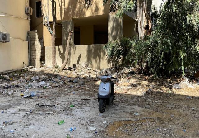 An empty lot where a store used to stand in Beirut. A moped is in the middle of the empty lot.