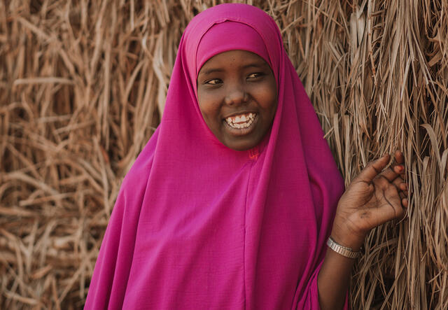 Ampiya is dressed in pink and smiling at the camera. 