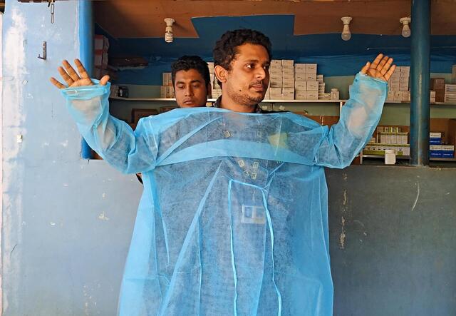 Dr Mahmudul Hossain clinical supervisor for the IRC's primary health care centre in Cox’s Bazar, Bangladesh, demonstrates PPE.