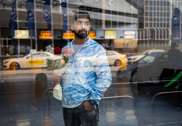 Medhi waits outside Frankfurt airport for his younger brother.