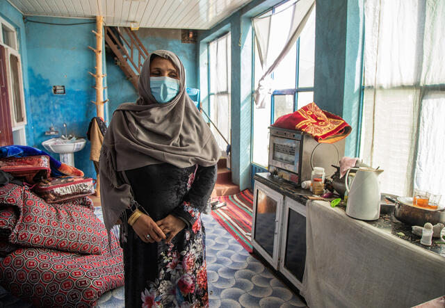 Noor stand in her aunts kitchen where her family are staying temporarily after fleeing their home.