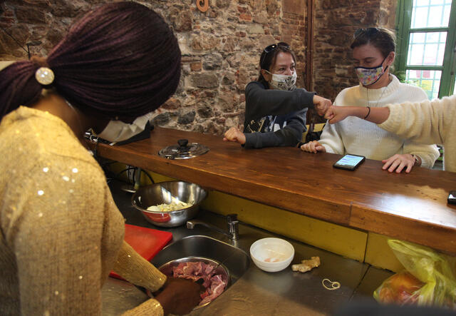 Elisabeth speaking to local's while preparing her recipe  