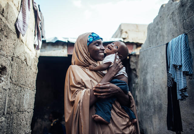 IRC client hugs and smiles with her baby son.