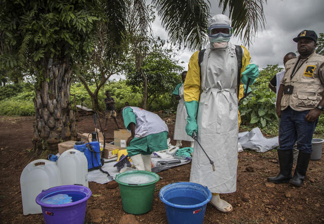 Health workers get dressed in full personal protective gear 