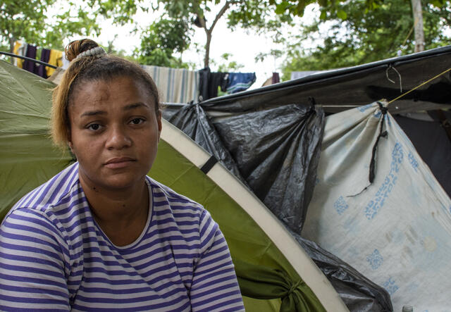 Angie, four months pregnant, sits outside her tent under a tree in Baranquilla.