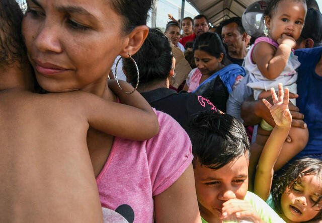 A Central American family waits to cross a border on their way to seek asylum in the U.S.