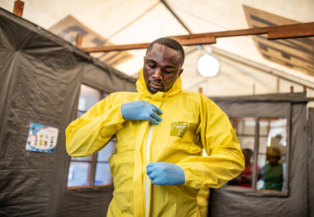 A health worker in the Democratic Republic of Congo puts on his jumpsuit and other protective gear to care for potential Ebola patients.