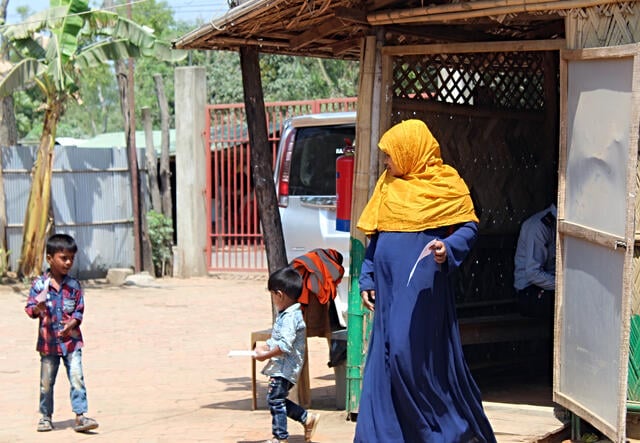 Sakera and her sons outside the outpatient area of the IRC primary health care center in Cox's Bazar