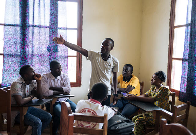 청소년 지도자 벤자민은 국제구조위원회가 지원하는 에볼라 관련 교육을 실시하면서 10대들이 앉아 있는 원형 안에 서 있습니다.