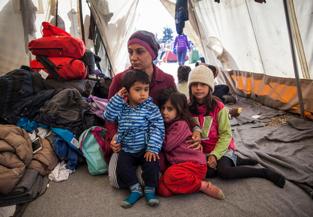 A displaced family inside a tent in a refugee settlement