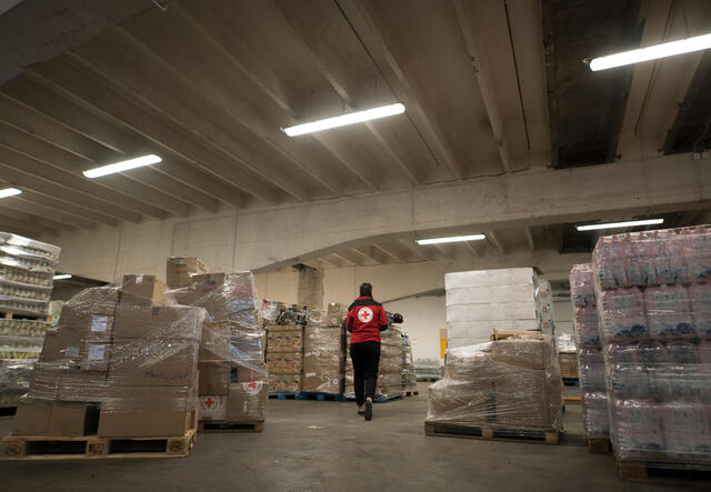 A medical person walking through a storage room.